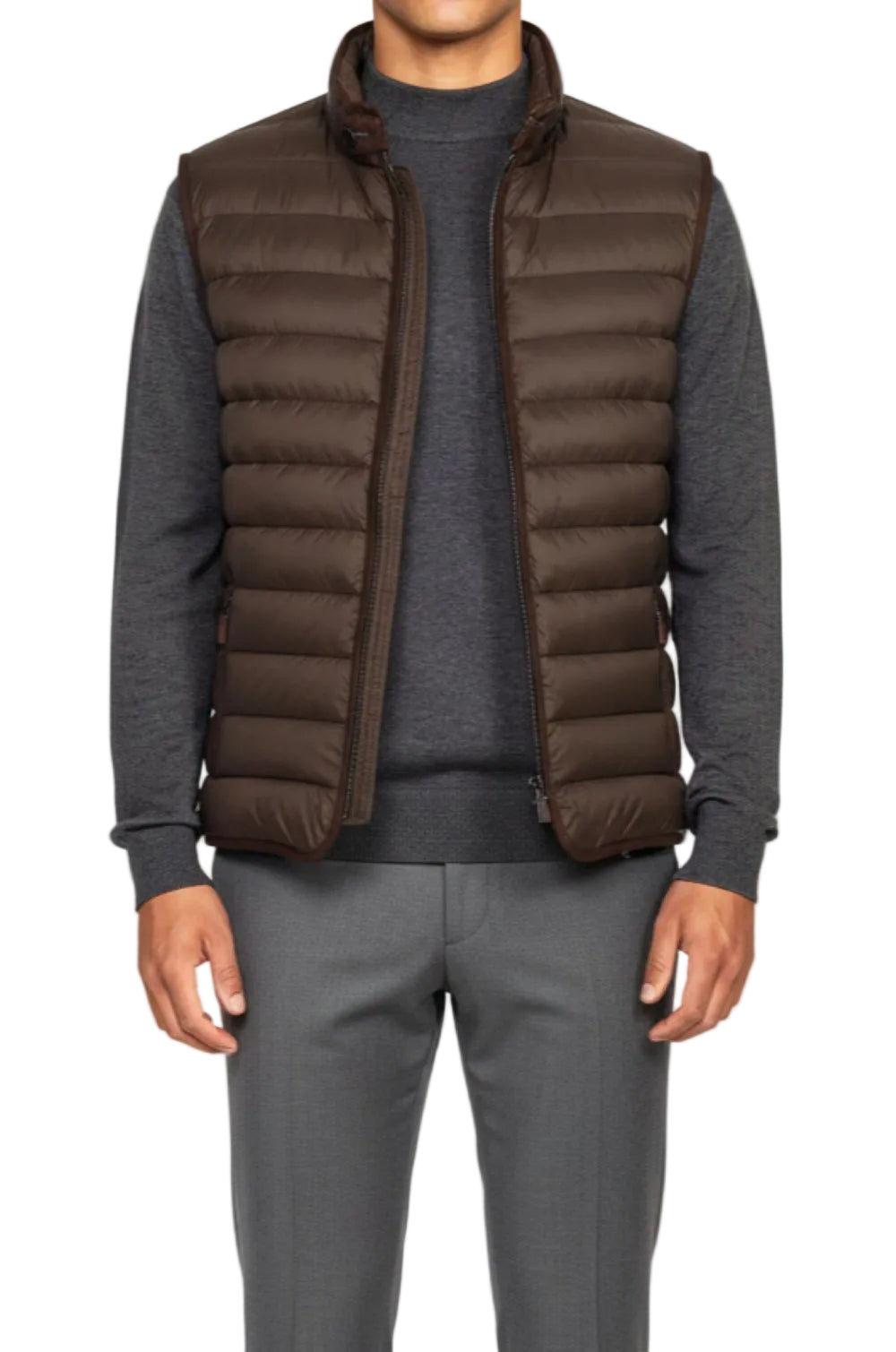 Man wearing a brown puffer vest over a gray sweater on a white background