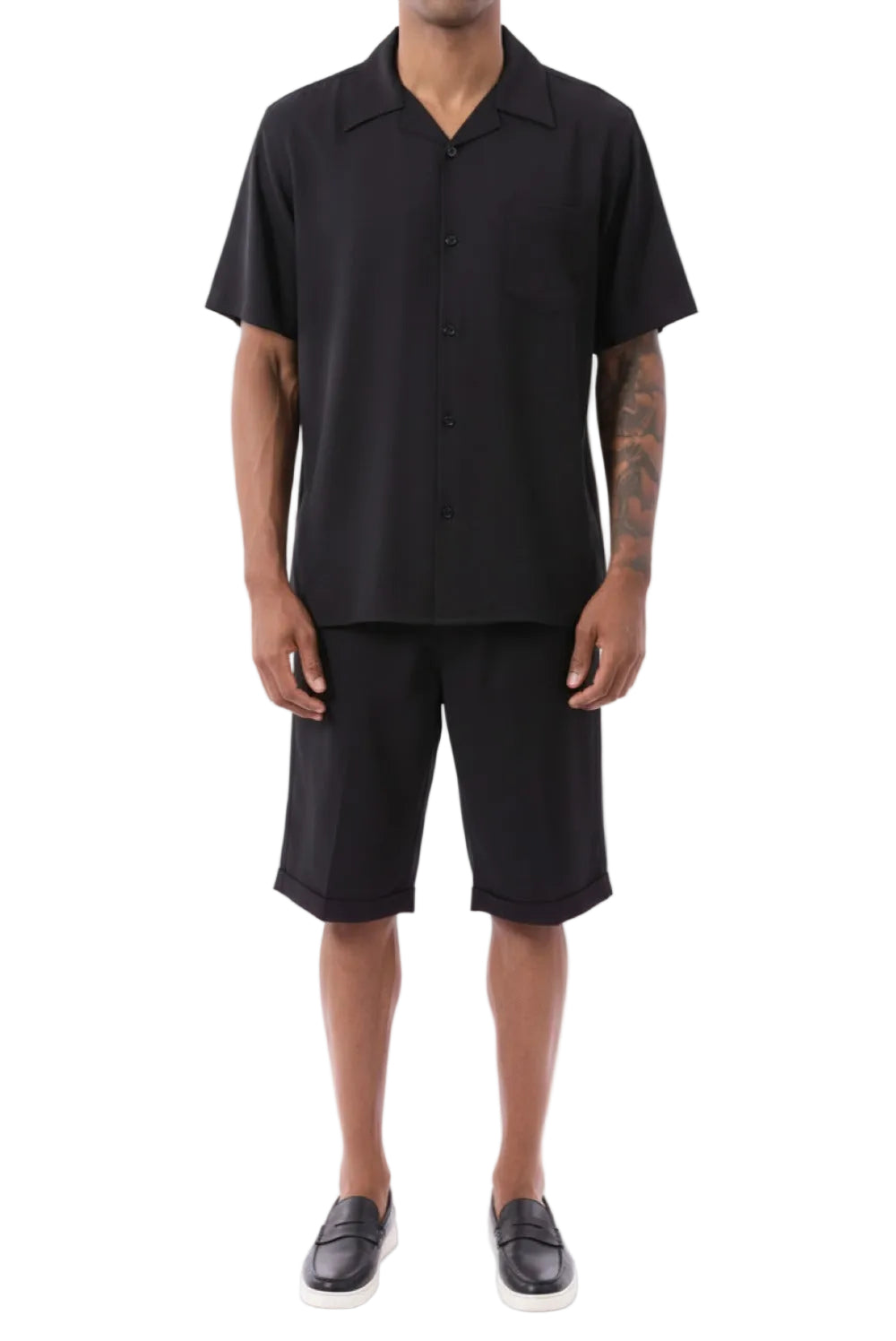 Person wearing a black polo shirt and shorts on a white background