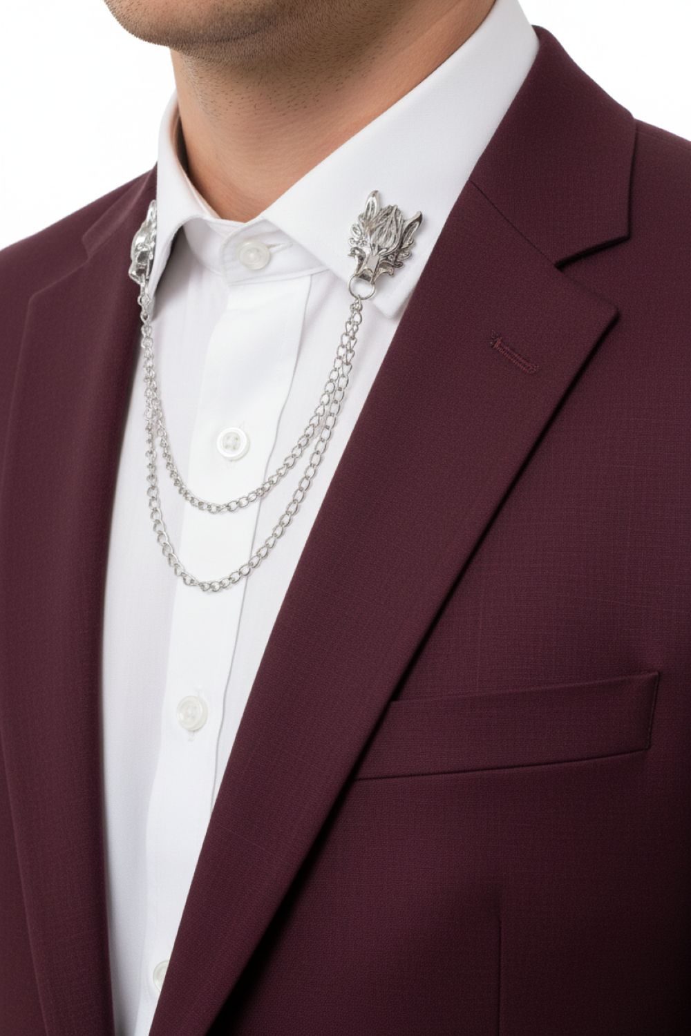 Close-up of a person wearing a burgundy suit jacket with a white shirt and silver chain necklace.